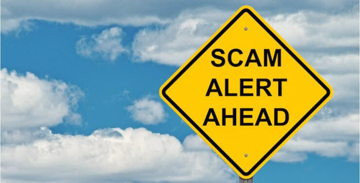 Warning sign reading Scam alert ahead