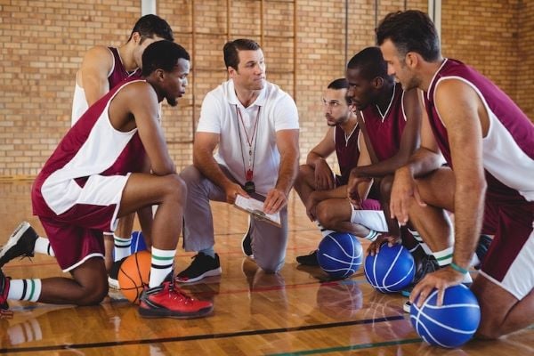 coach discussing coaching strategies with basketball team