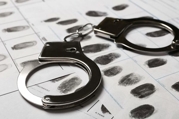 criminal justice handcuffs on fingerprint sheet